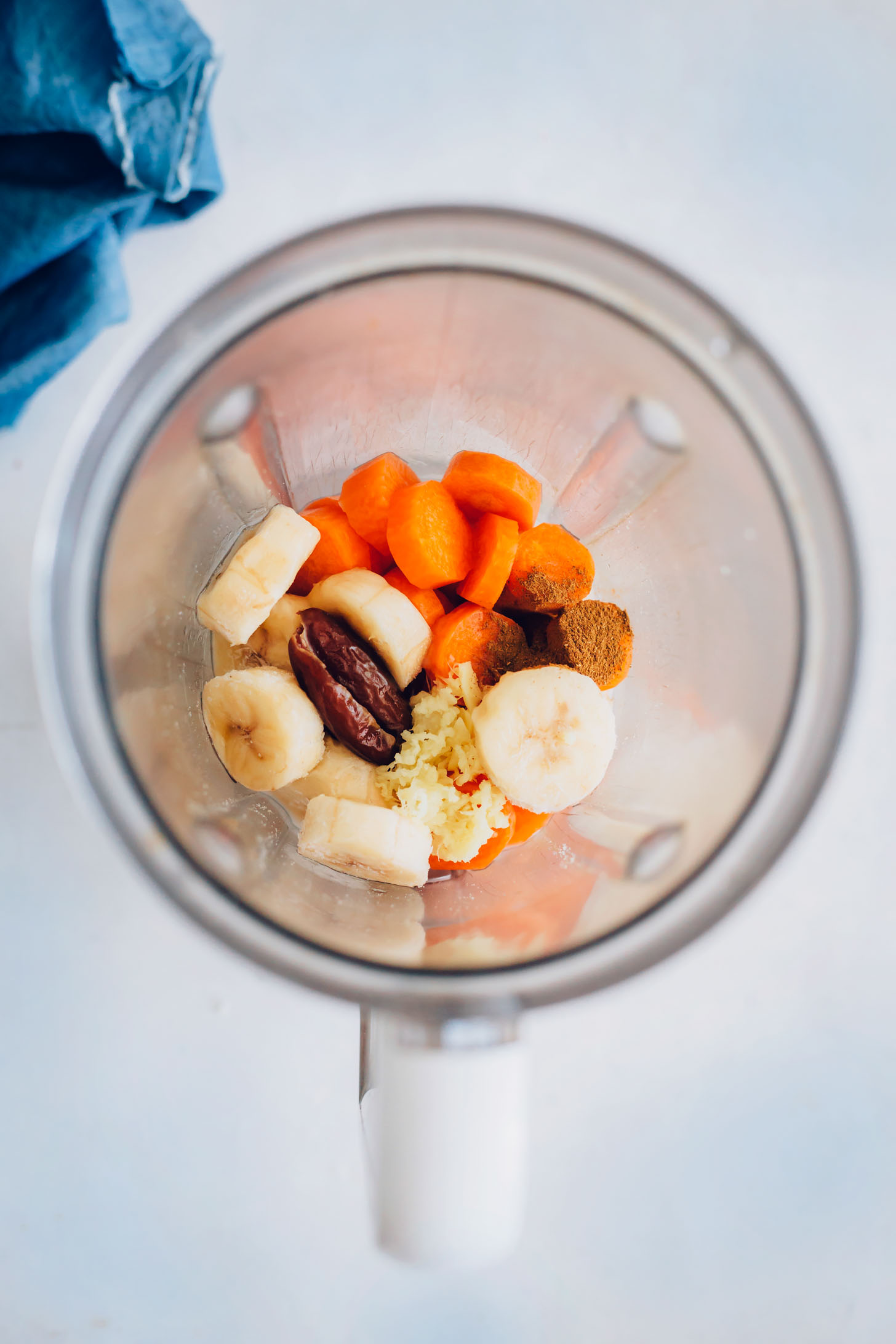 Blender with carrots, banana, date, ginger, and spices