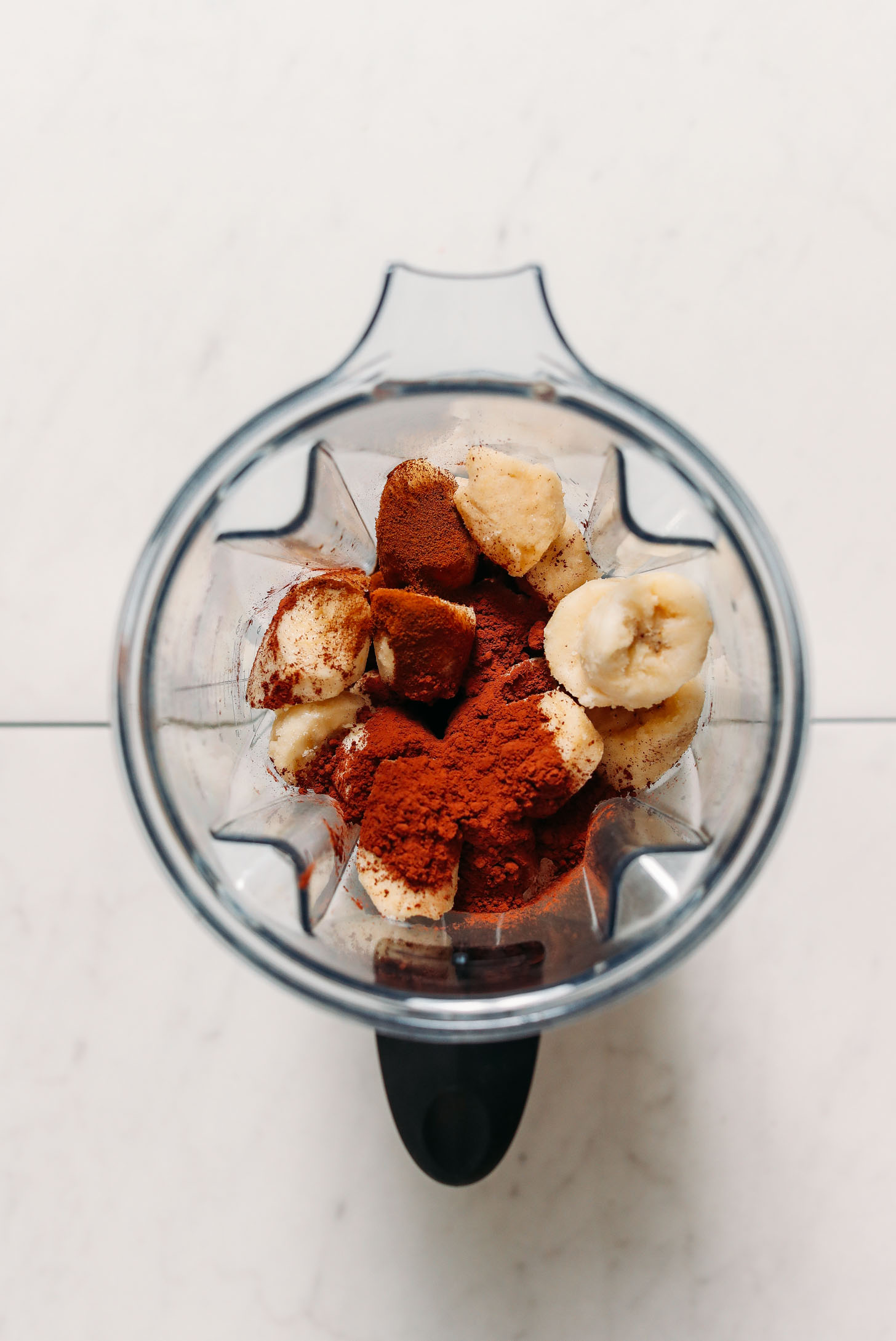 Sliced frozen bananas, cacao powder, and dandy blend in a Vitamix blender