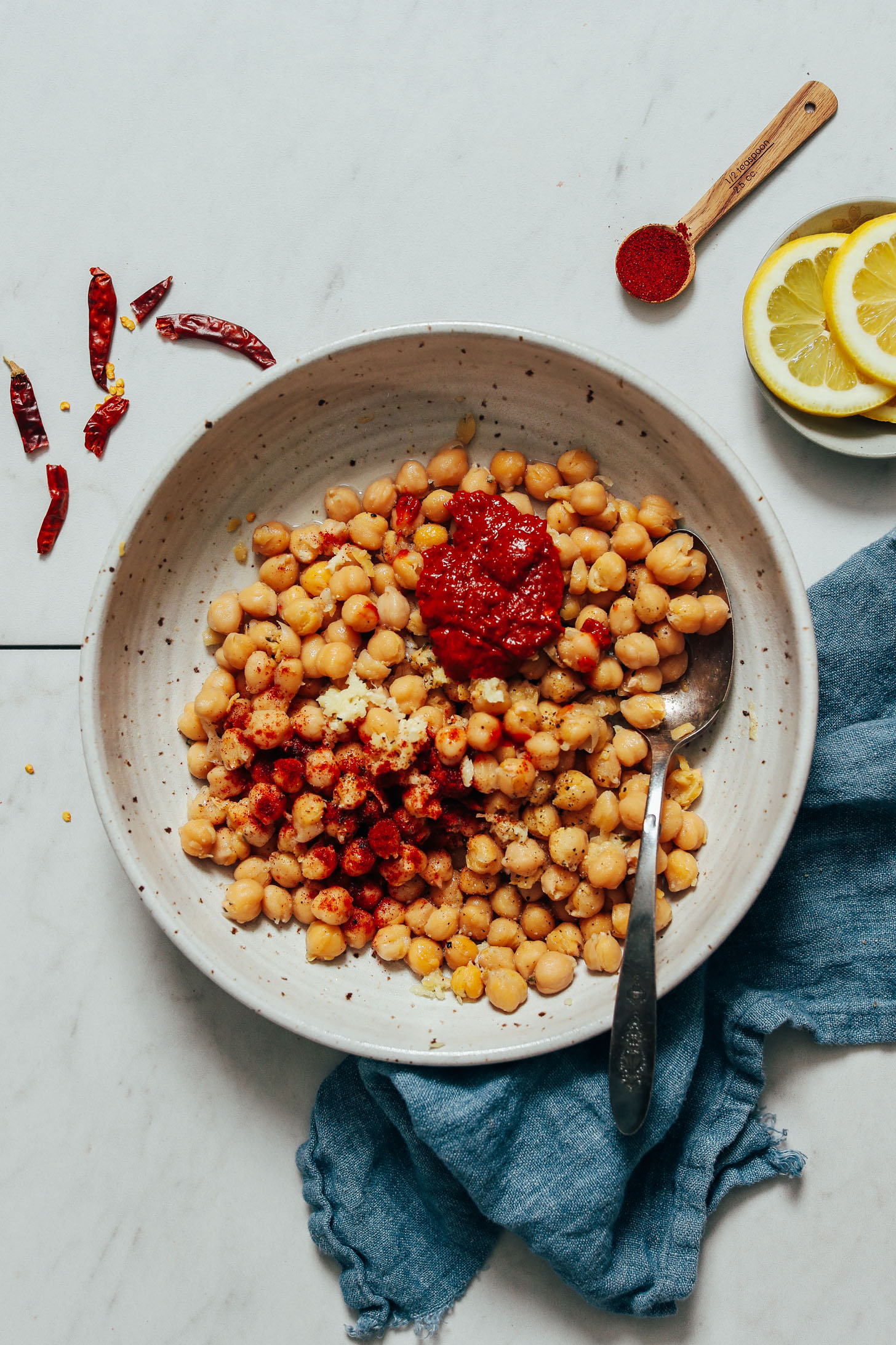 Spoon in a bowl of chickpeas with harissa, garlic, and smoked paprika