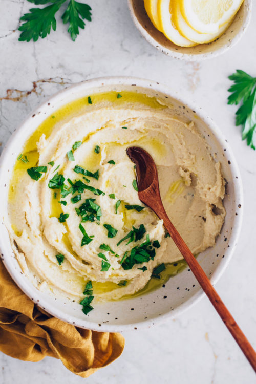 Wooden spoon in a bowl of vegan ricotta cheese