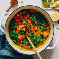 Wooden spoon in a pot of our Sweet Potato Chickpea Green Curry