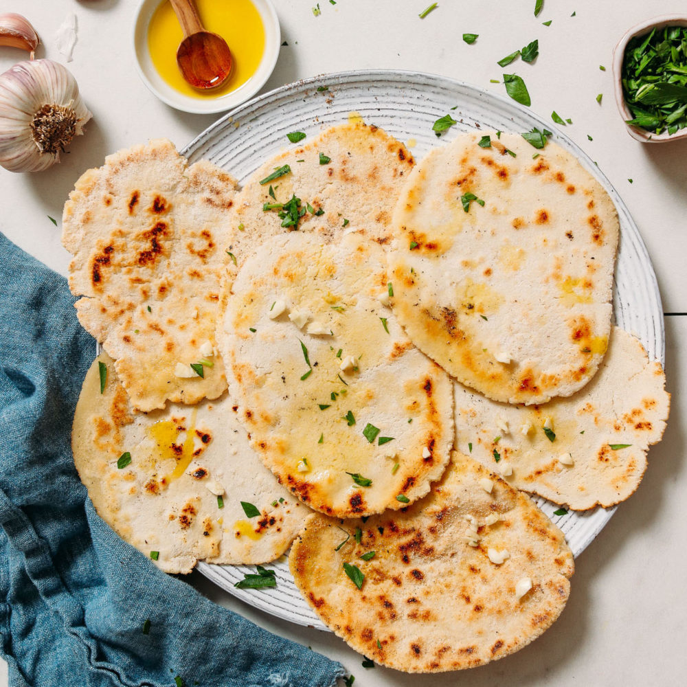 Plate of gluten free naan bread topped with fresh parsley