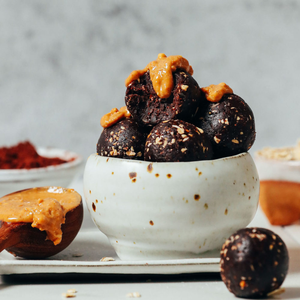 Bowl of Chocolate Cookie Energy Bites topped with peanut butter
