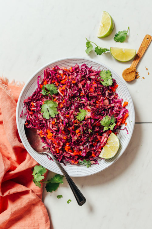 Bowl of Cabbage Slaw topped with fresh cilantro and lime