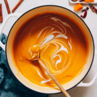 Coconut milk swirled in a pot of roasted butternut squash soup