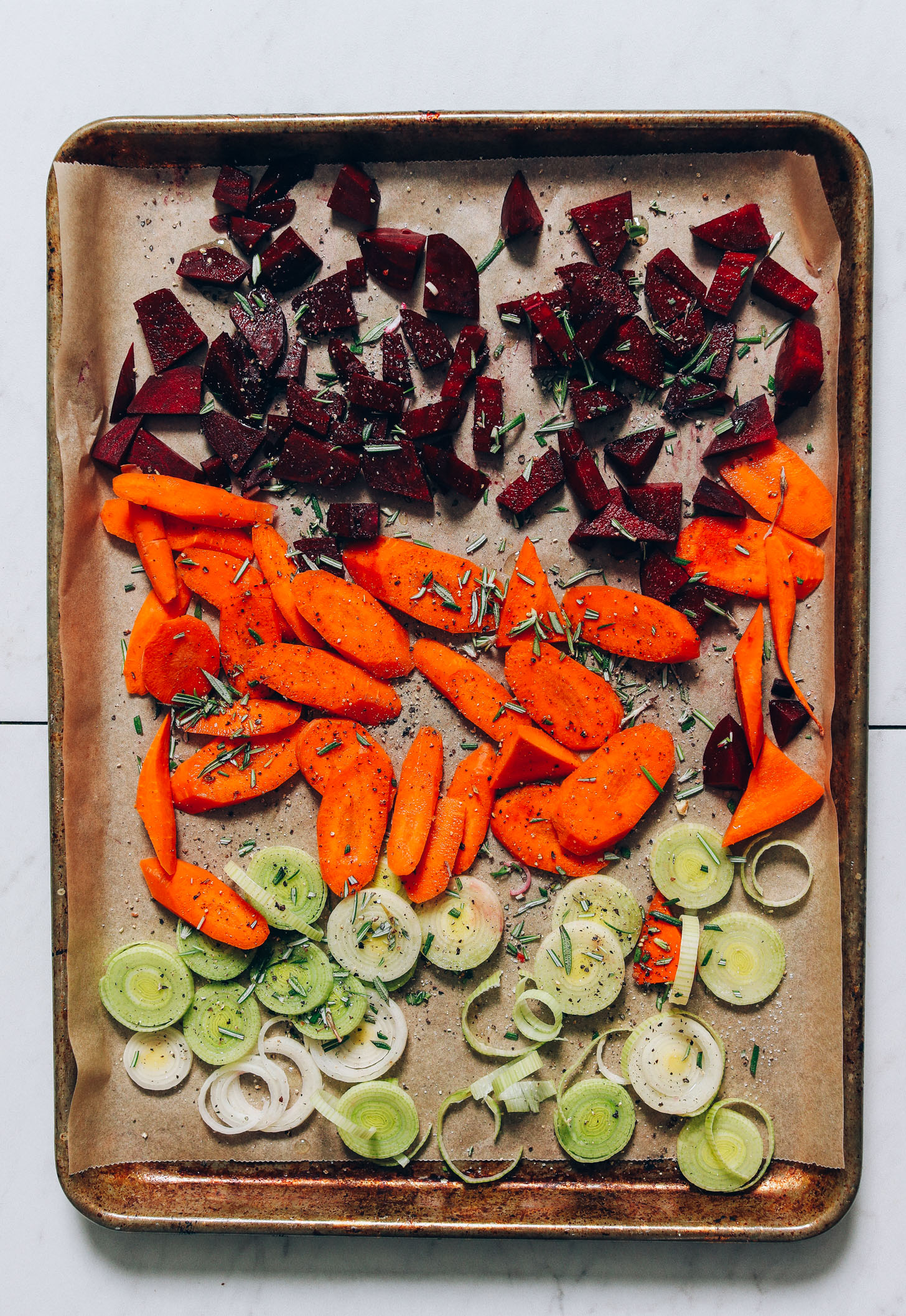 Baking sheet of beets, rosemary, carrots, and leeks