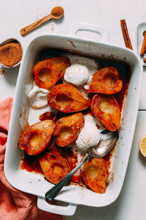 Baking dish of Easy Baked Pears with scoops of vegan vanilla ice cream