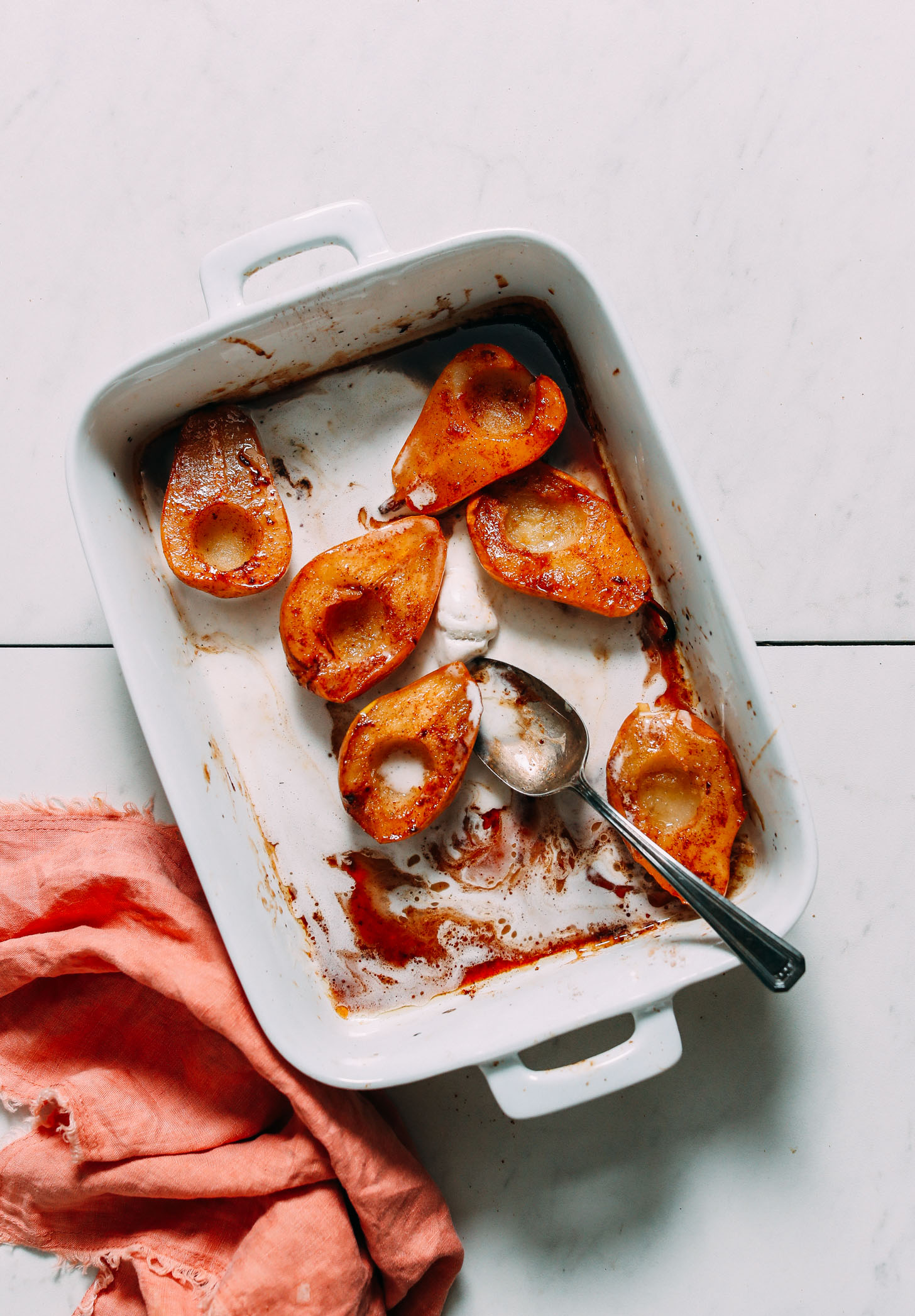 Baked pears and melted vegan vanilla ice cream in a white baking dish