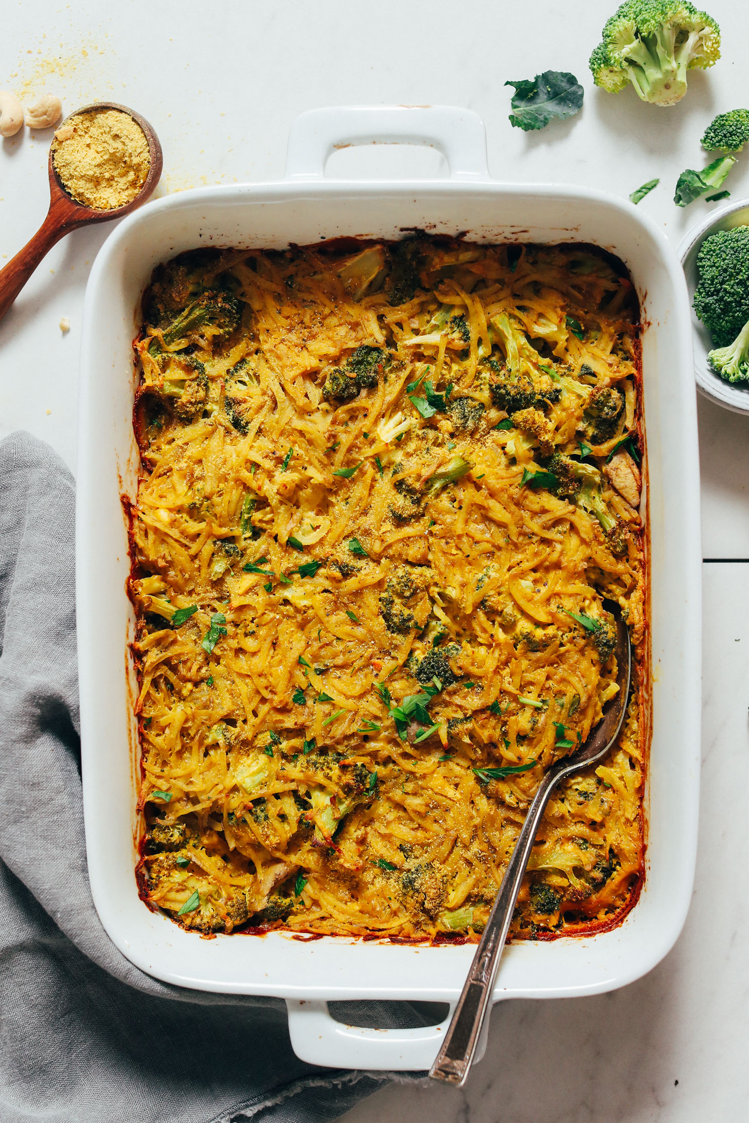 Vintage spoon in a pan of Cheesy Broccoli Hash Brown Bake