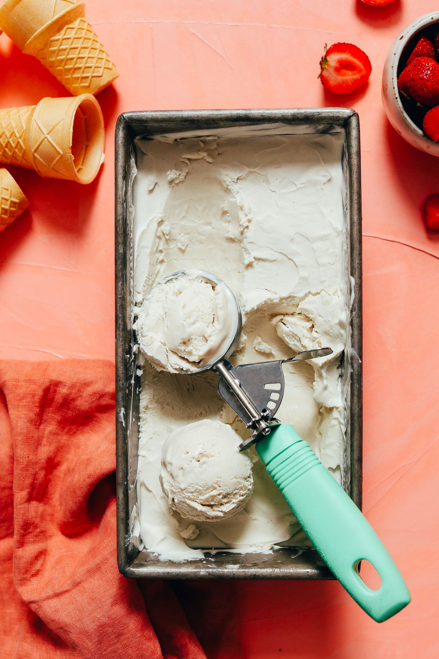 Loaf pan and ice cream scoop of creamy vegan vanilla ice cream