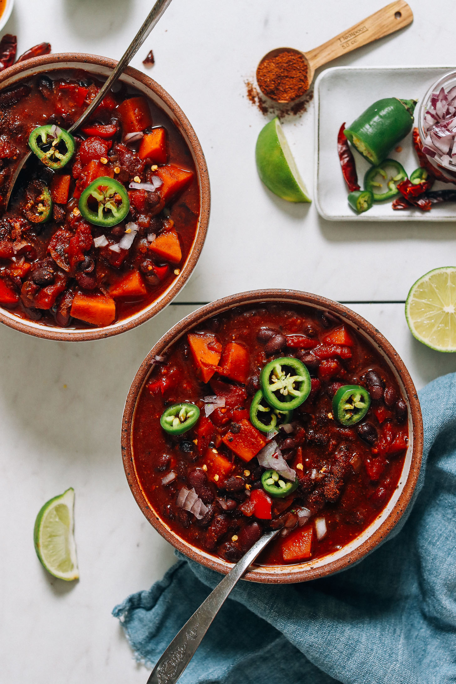 Two bowls of vegan Instant Pot Chili next to ingredients used to make it