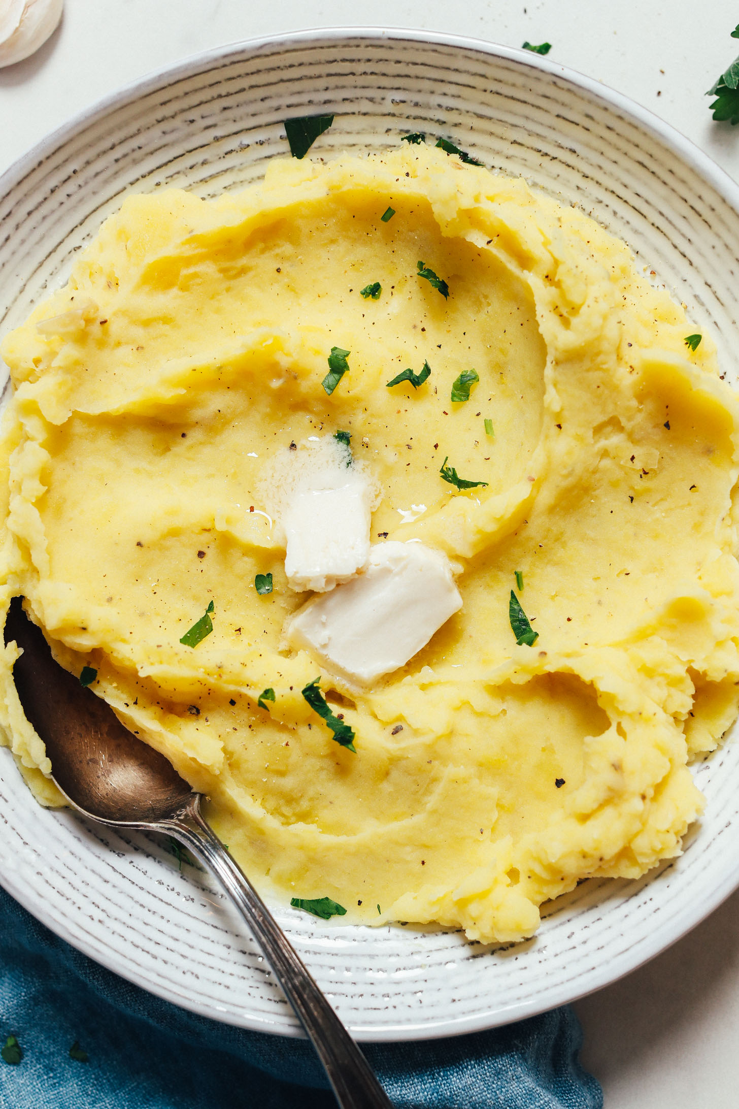Slices of vegan butter melting on a bowl of Instant Pot mashed potatoes