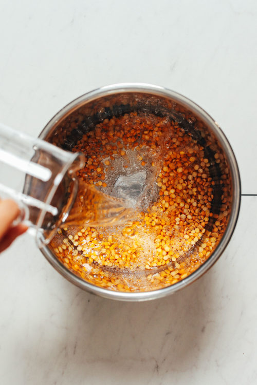 Pouring water into a pot of yellow split peas