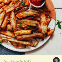 Platter of oil-free baked fries with cajun seasoning and ketchup