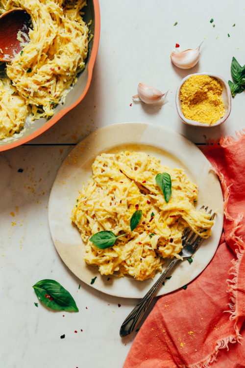 Plate and pan of Instant Pot spaghetti squash pasta with fresh basil