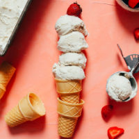 Scoops of homemade vegan vanilla ice cream on a stack of cones
