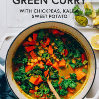 Dutch oven filled with green curry with sweet potato, kale, and chickpeas