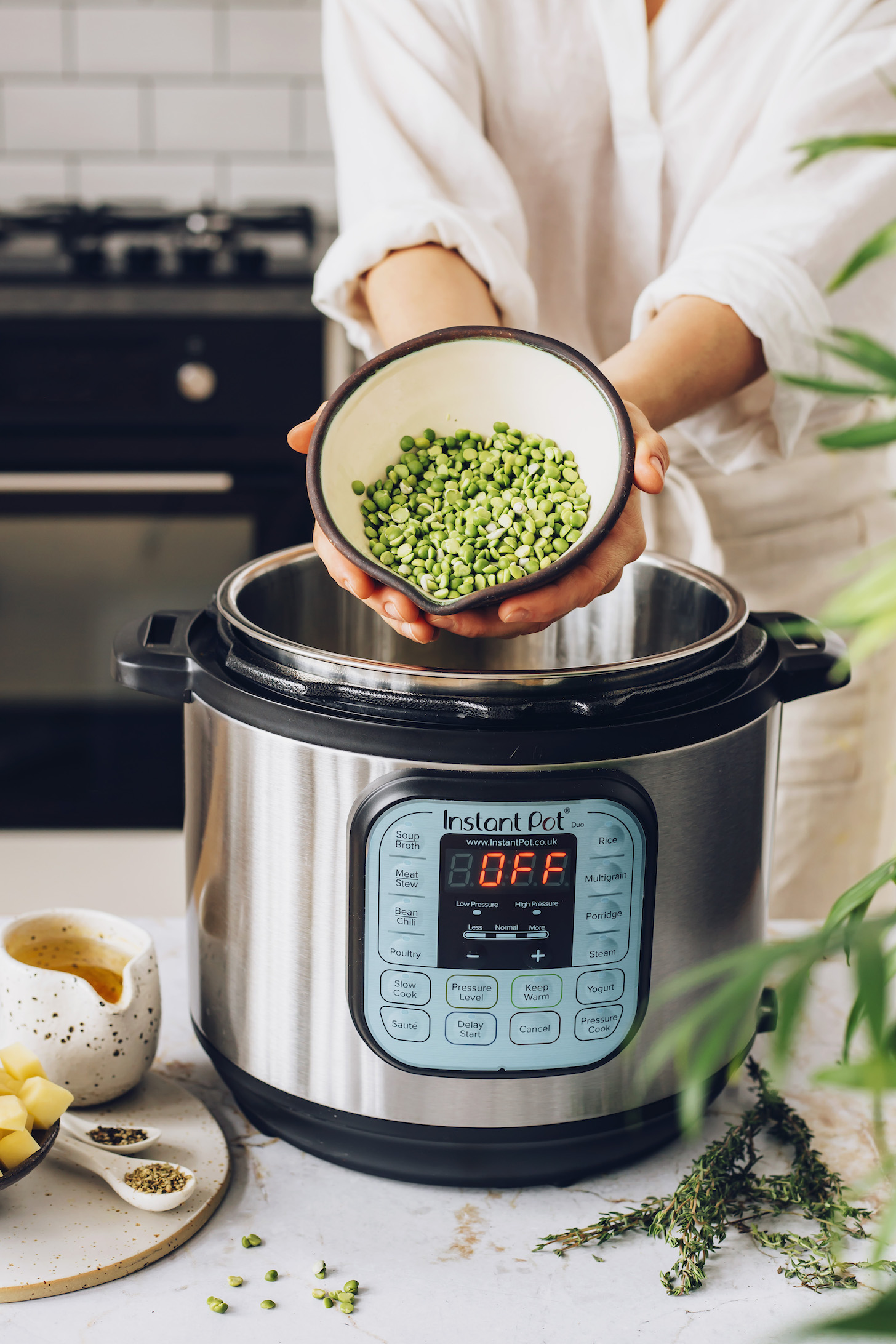 Holding a bowl of dry green split peas over an Instant Pot