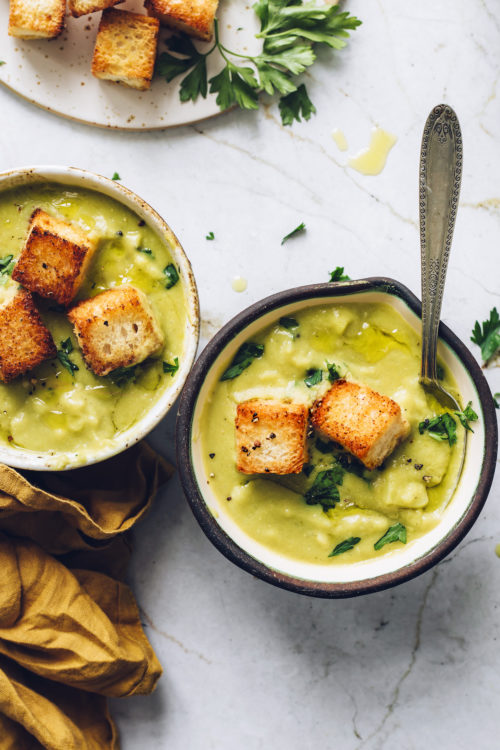 Bowl of green split pea soup topped with jumbo croutons