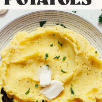 Bowl of mashed potatoes with text above saying Instant Pot Mashed Potatoes no drain and 20 minutes