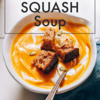 Bowl of butternut squash soup topped with homemade croutons and pepitas