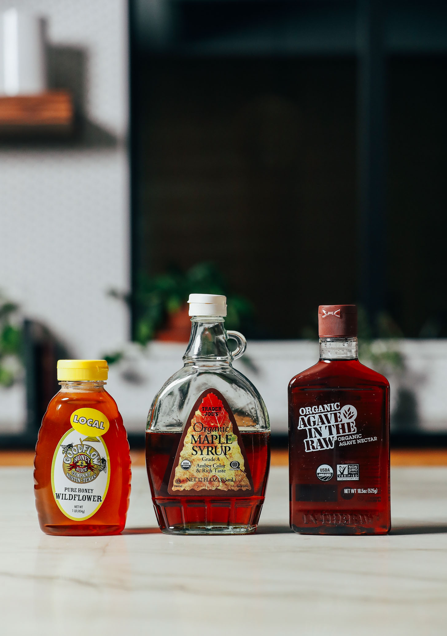 Bottles of honey, maple syrup, and agave