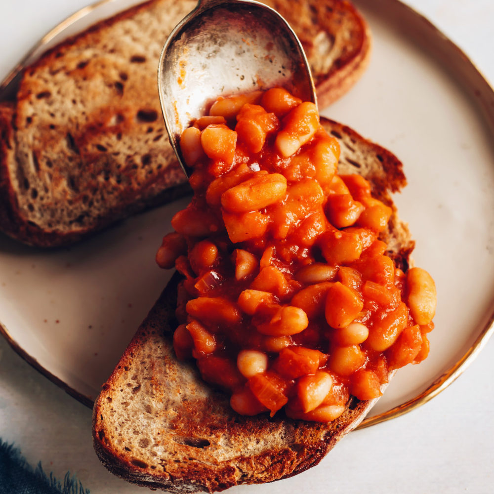 Topping two slices of toast with British baked beans