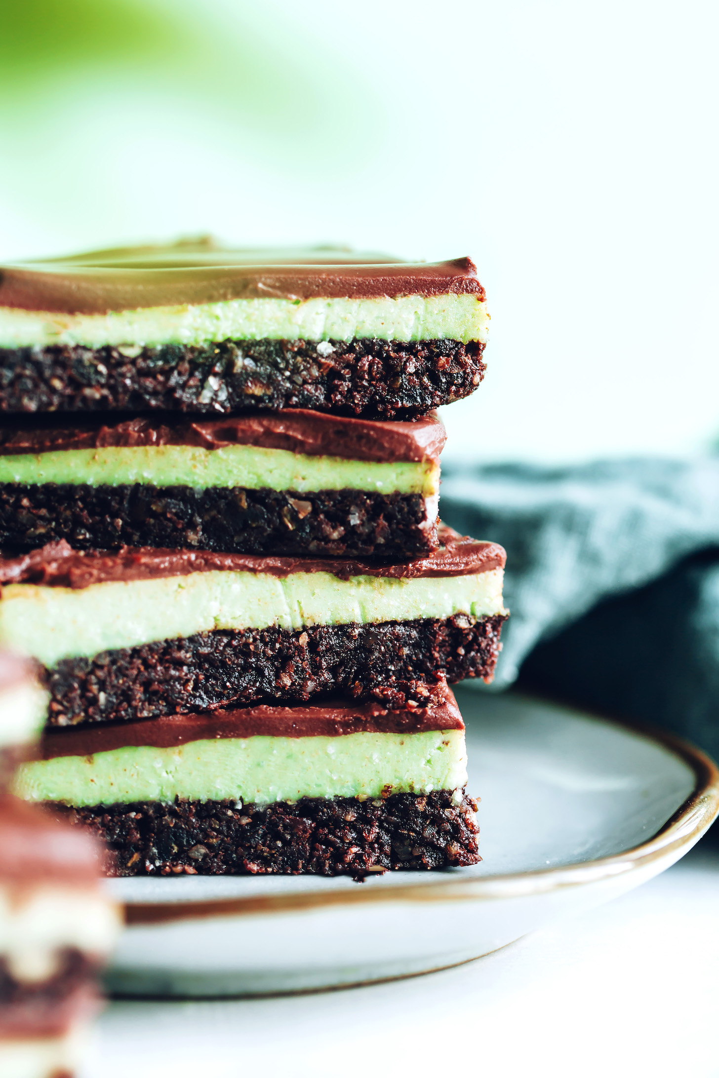 Plate with a stack of no-bake chocolate mint brownie bars