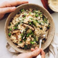 Bowl of vegan risotto with miso, spring vegetables, and vegan parmesan