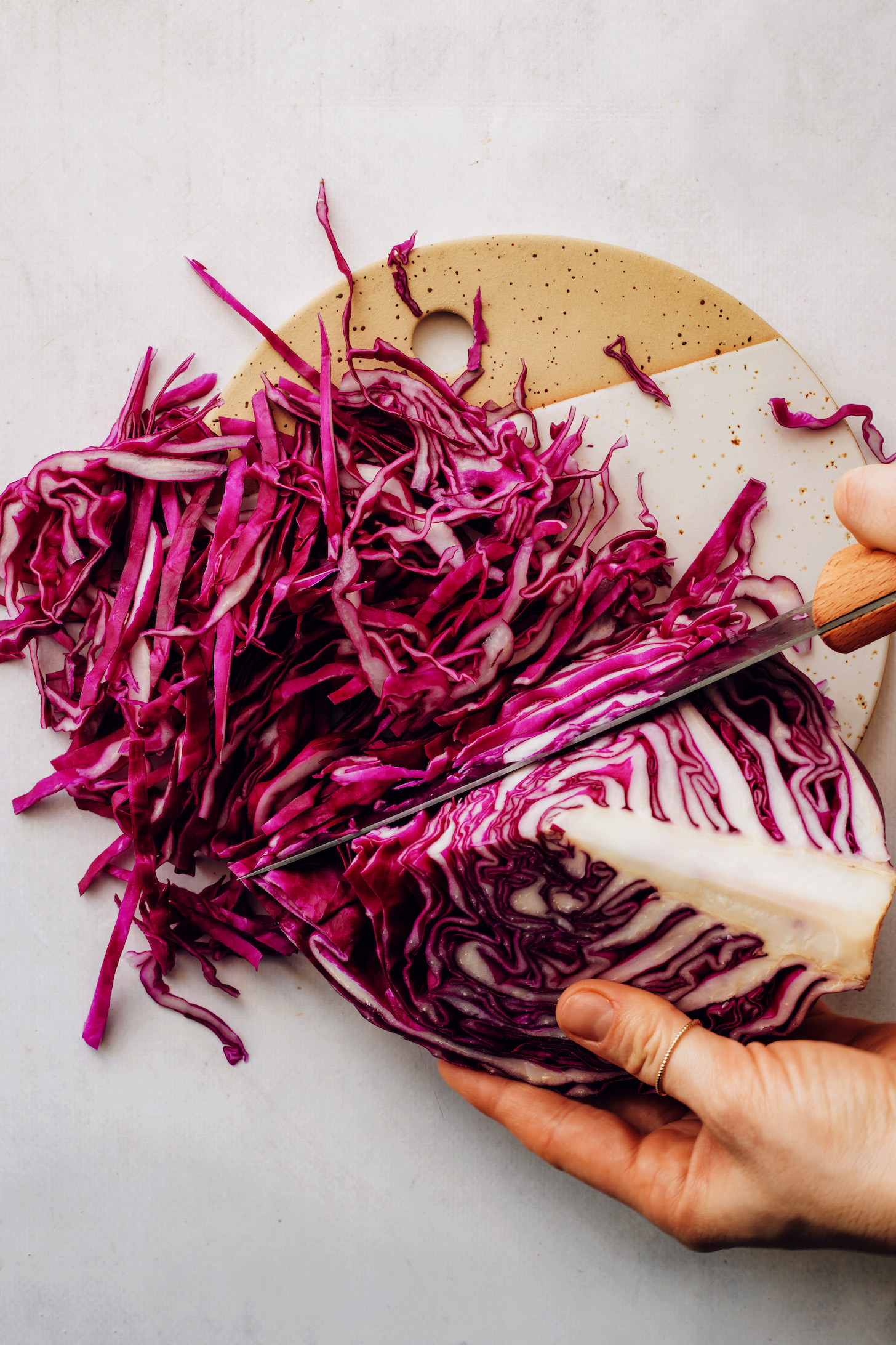 Using a large knife to slice red cabbage