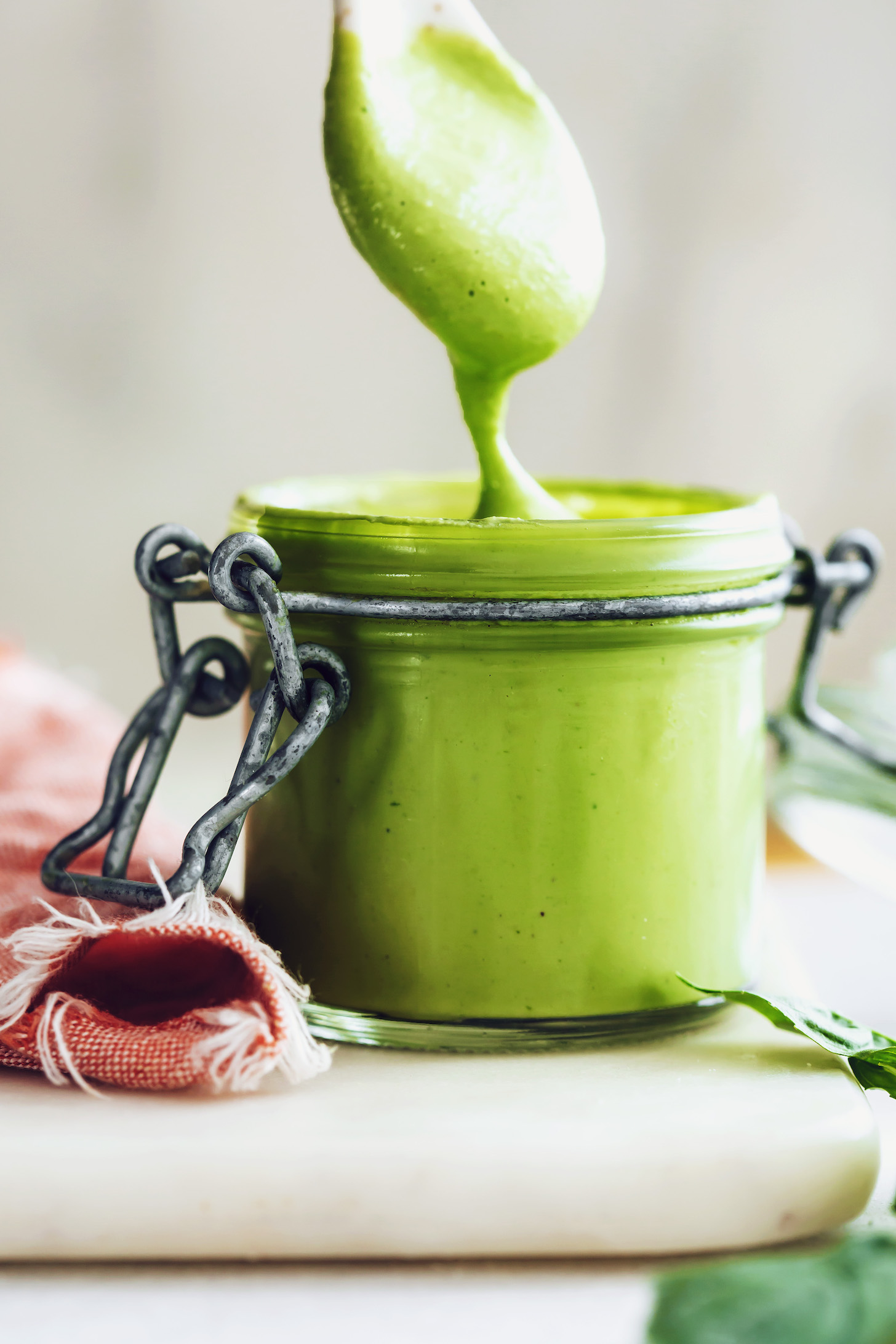 Jar and spoon coated in our green goddess dressing recipe