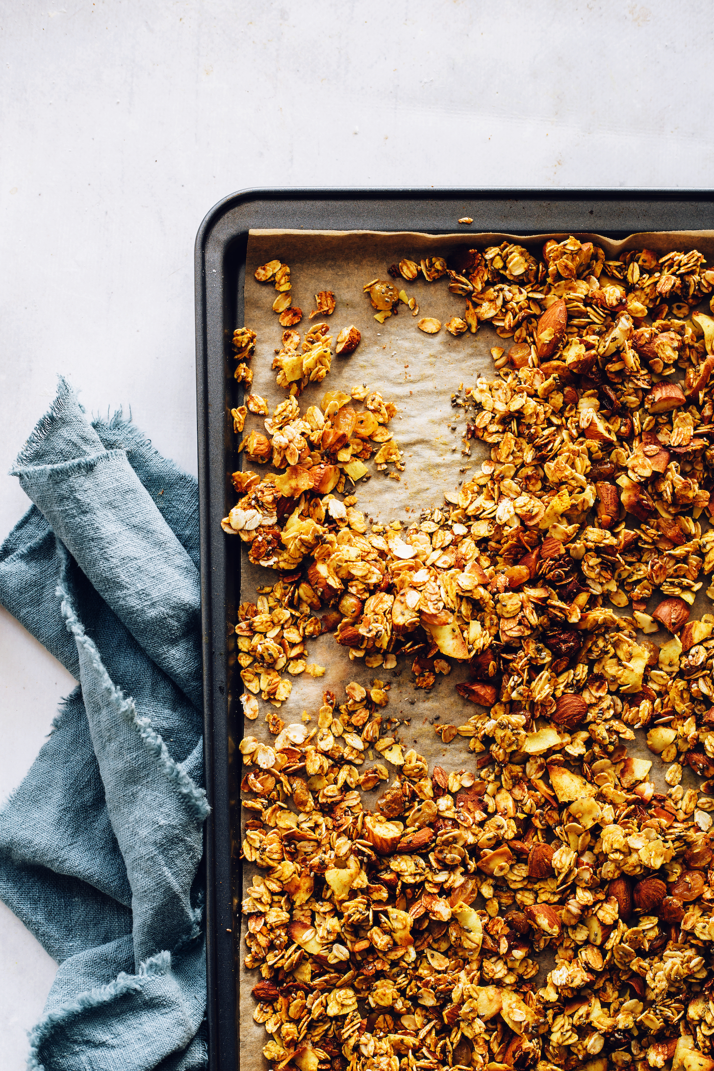 Parchment-lined baking sheet filled with golden milk granola