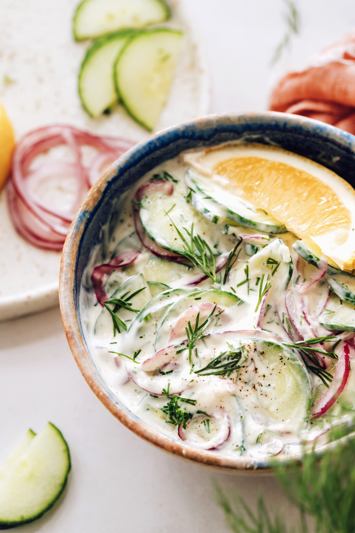 Bowl of creamy cucumber onion salad with fresh dill