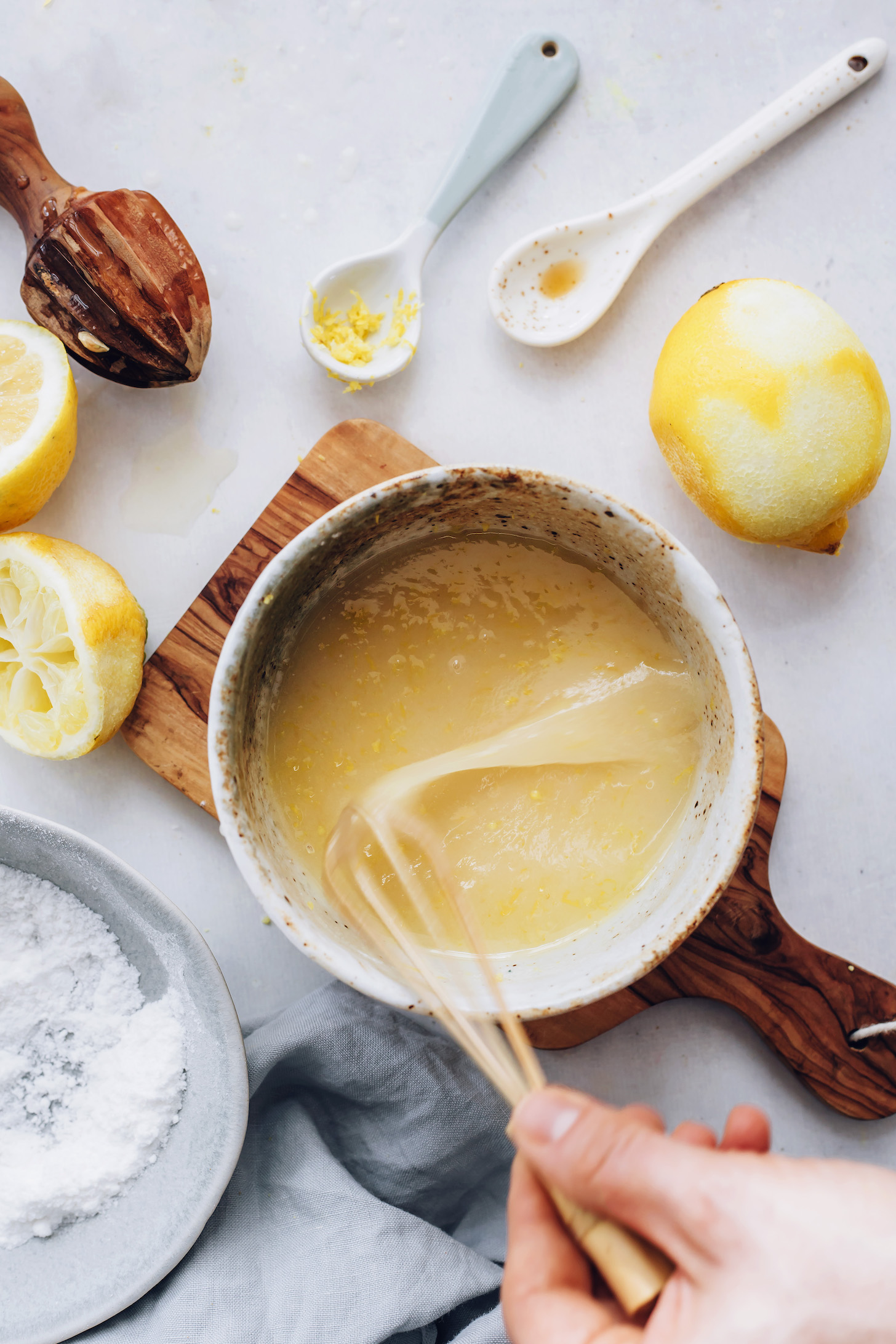 Whisking lemon glaze ingredients in a small bowl