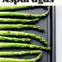 Spears of asparagus on a baking sheet with text that reads Perfect Roasted Asparagus 1 Pan and 15 Minutes