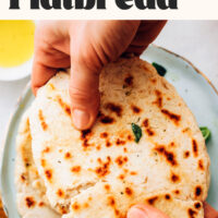 Holding a piece of homemade gluten-free flatbread above a plate with text that says 20 minutes and 1 bowl