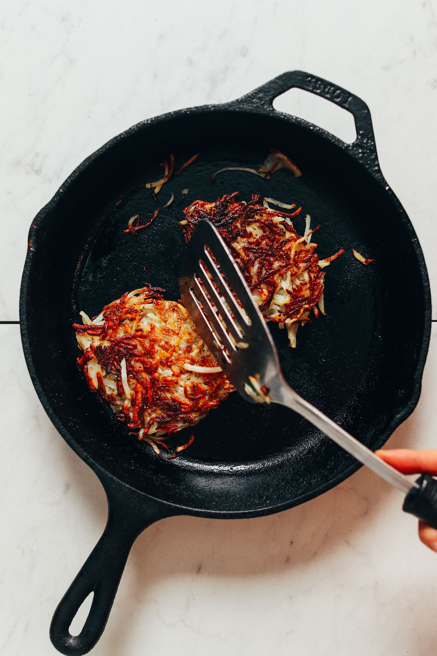 Crispy hash brown patties in a cast iron skillet
