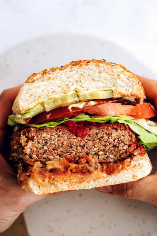 Holding our vegan burger in a bun with lettuce, tomato, and more