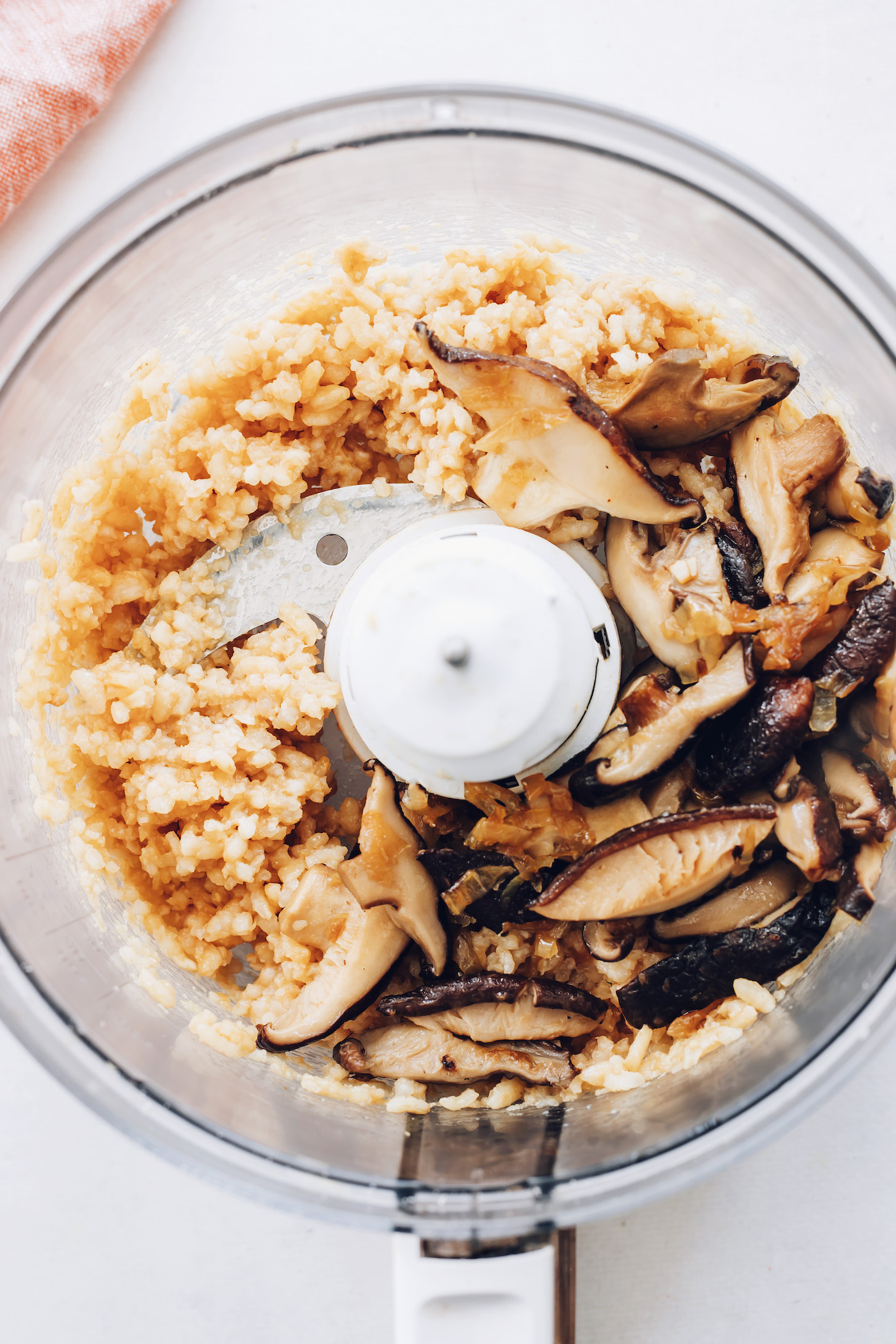 Food processor with cooked rice and sautéed mushrooms and onions