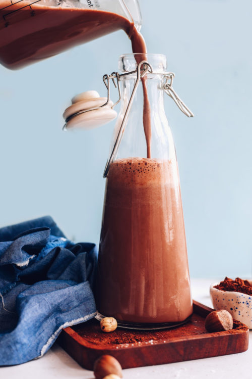 Pouring chocolate hazelnut milk into a glass jug