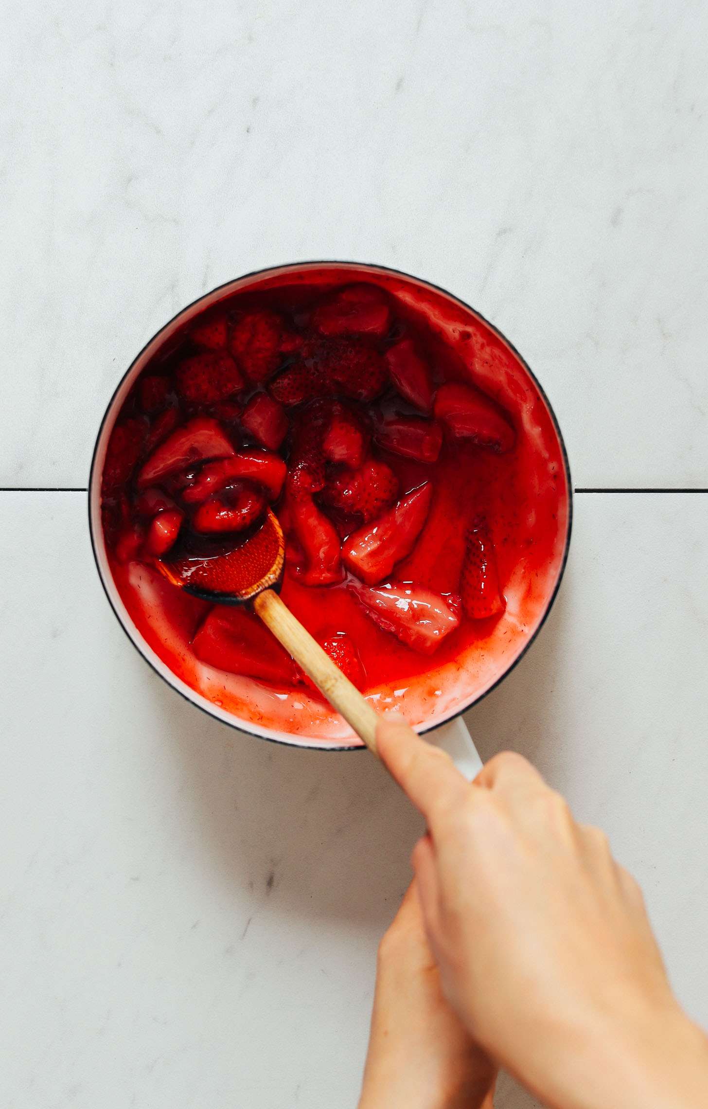 Stirring strawberry compote in a saucepan