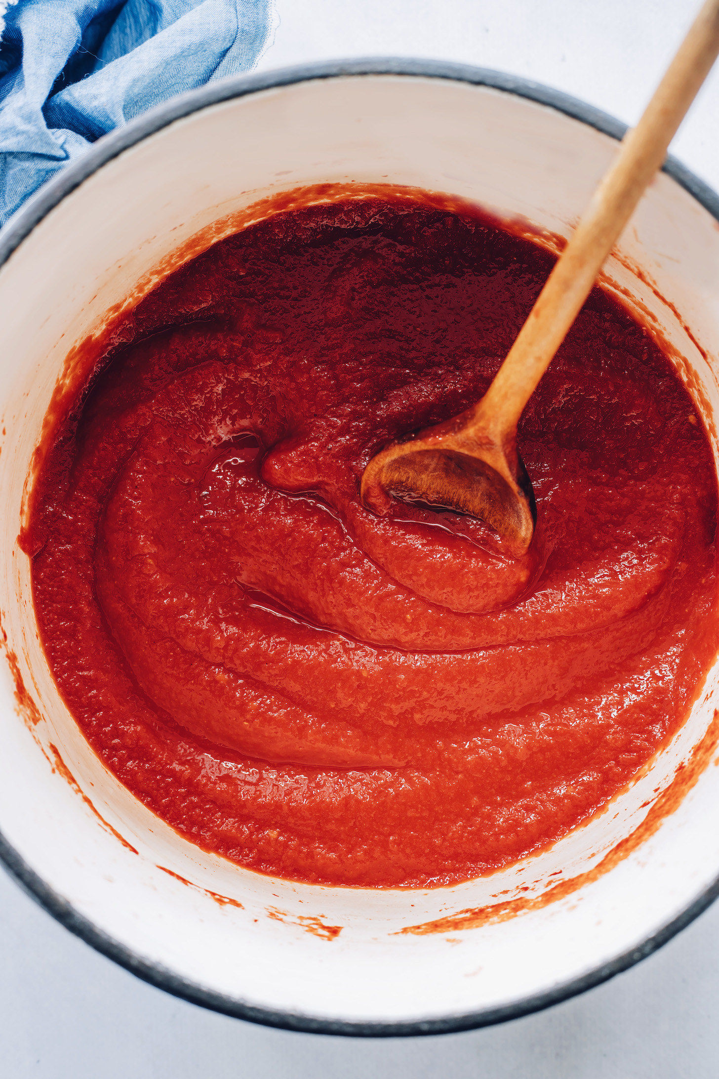 Wooden spoon in a pot of our homemade ketchup recipe
