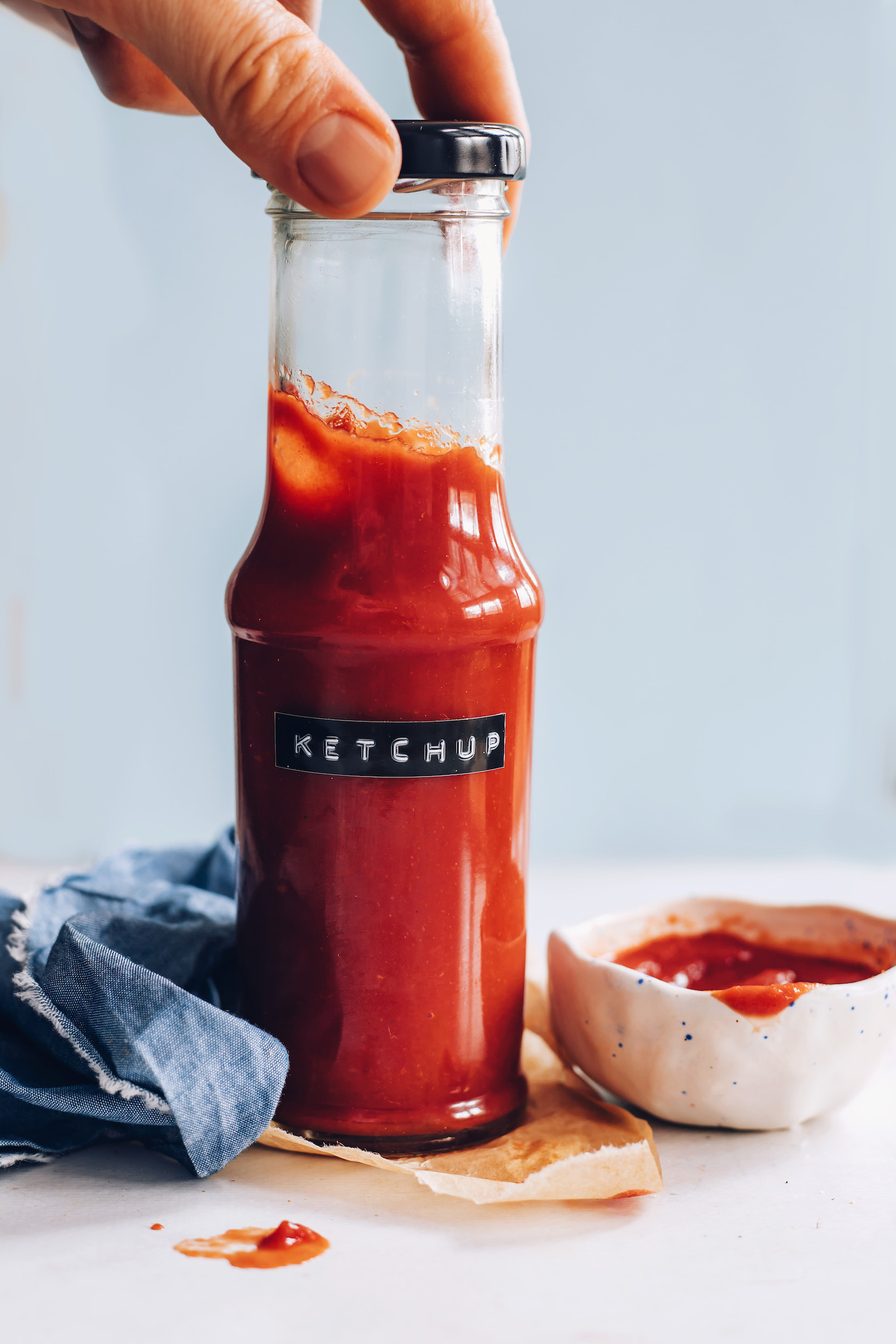 Holding the top of a bottle of homemade ketchup