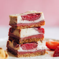 Stack of three gluten-free vegan strawberry cheesecake bars