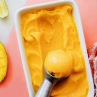 Ice cream scoop in a pan of easy mango sorbet