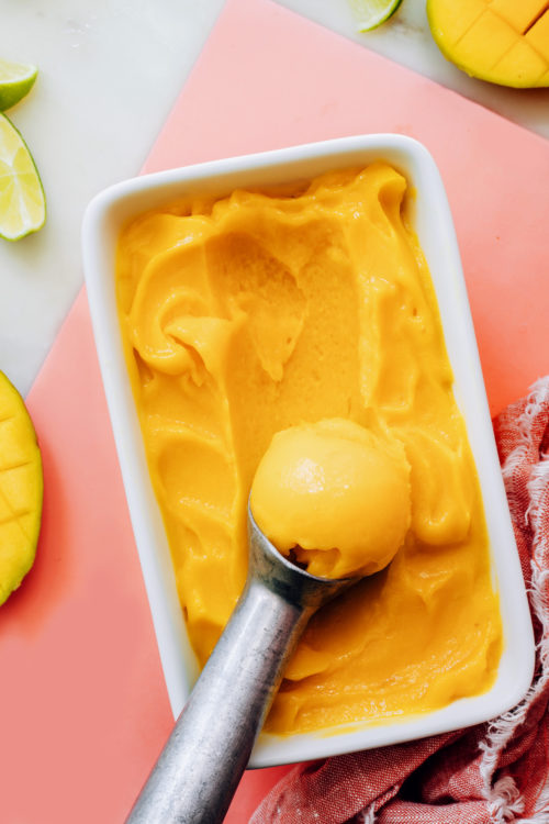 Ice cream scoop in a pan of easy mango sorbet