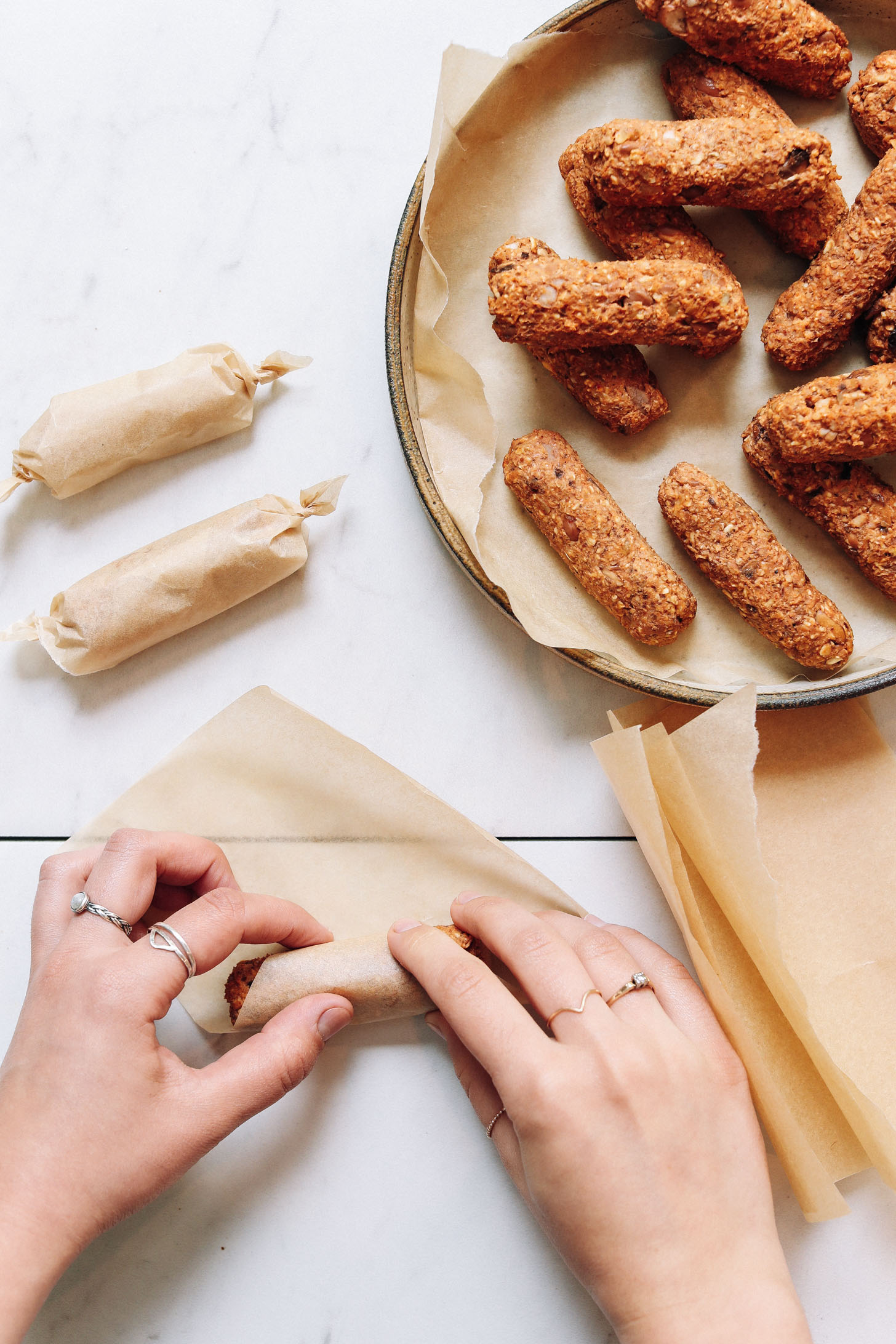 Rolling a vegan sausage link in parchment paper