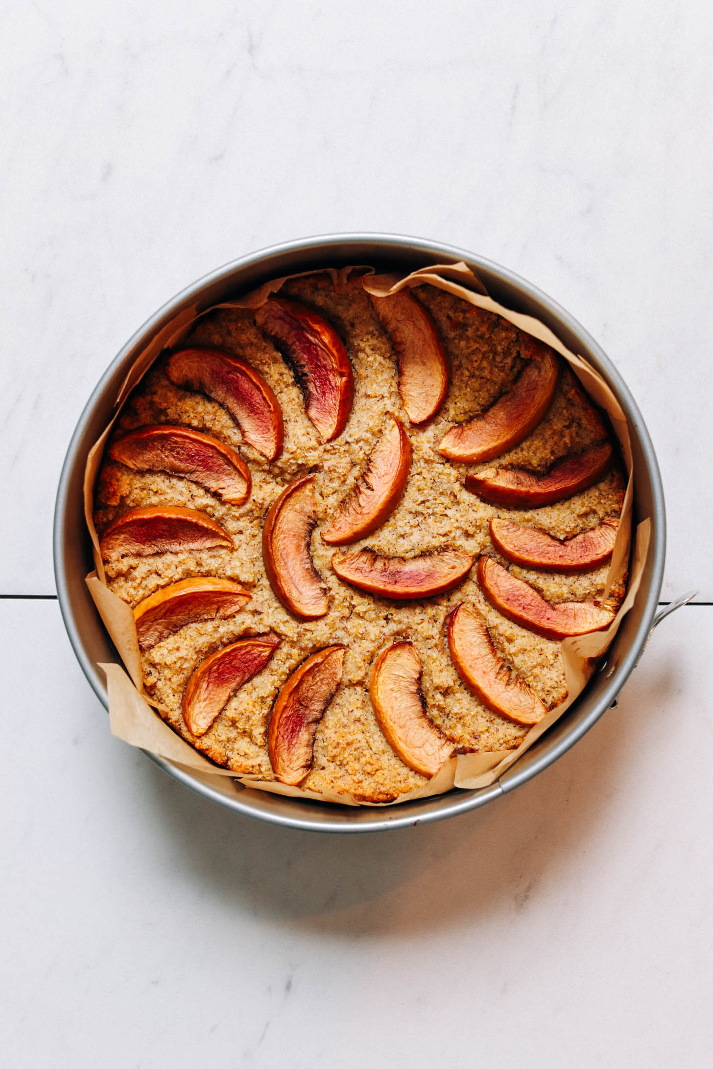 Top down shot of millet breakfast cake with nectarines