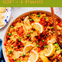 Bowl of easy vegan paella with lemon wedges, green peas, and vegan chorizo