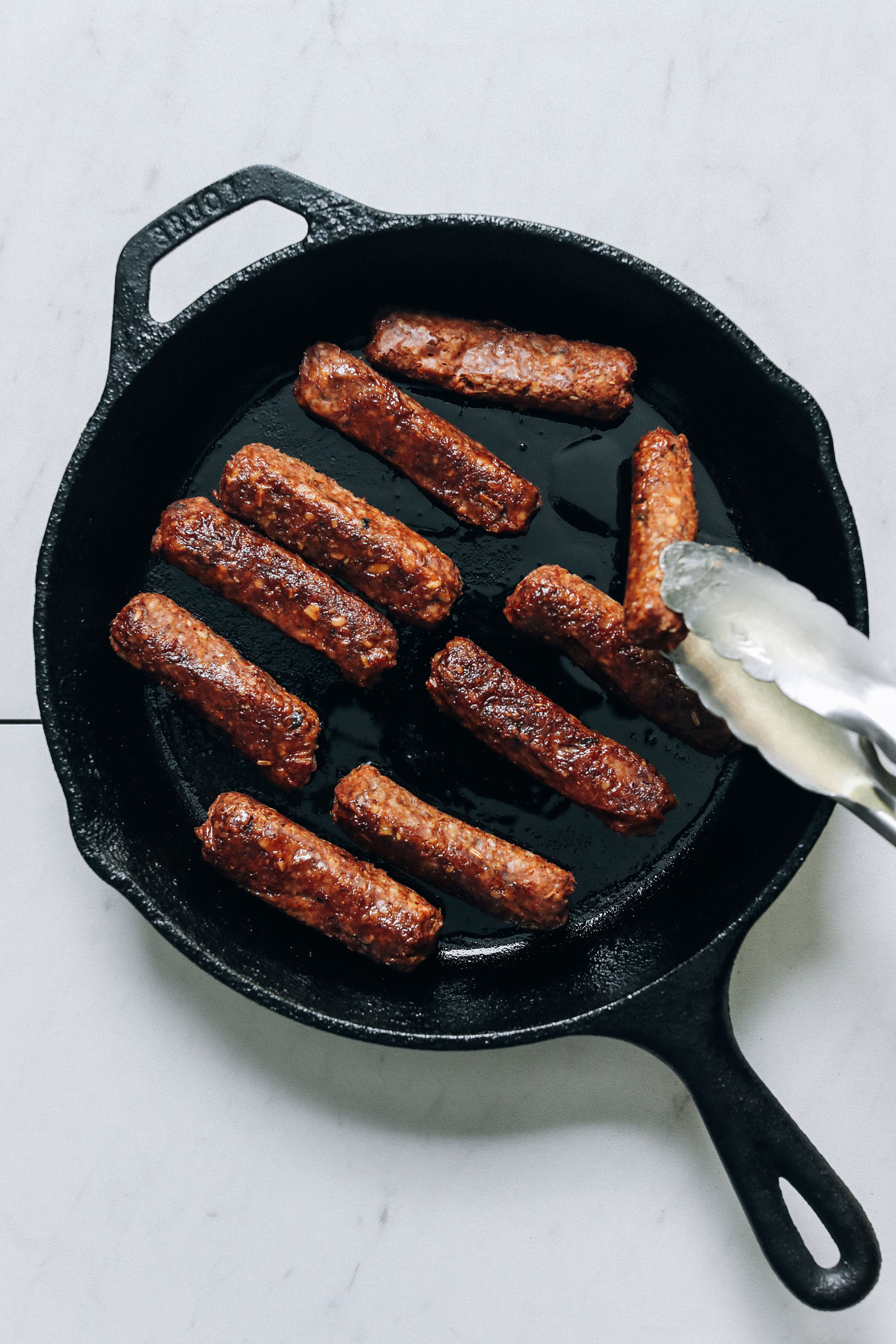 Cooking vegan sausage links in a cast iron skillet
